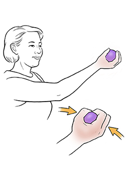 Woman doing ball squeeze exercise.