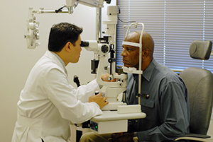 Heathcare provider examining man's eyes.