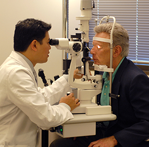 Heathcare provider examining man's eyes.