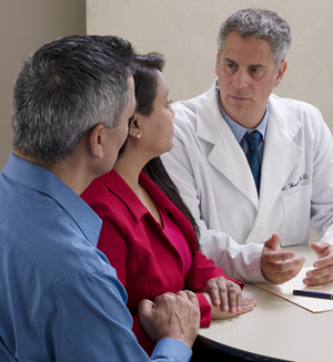 Hombre y mujer que hablan con un proveedor de atención médica.