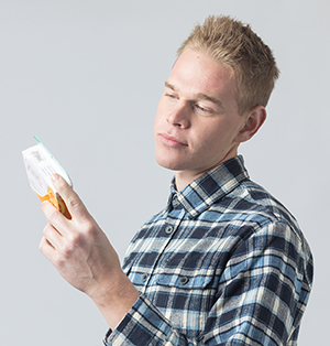 Man reading box of over-the-counter medication.